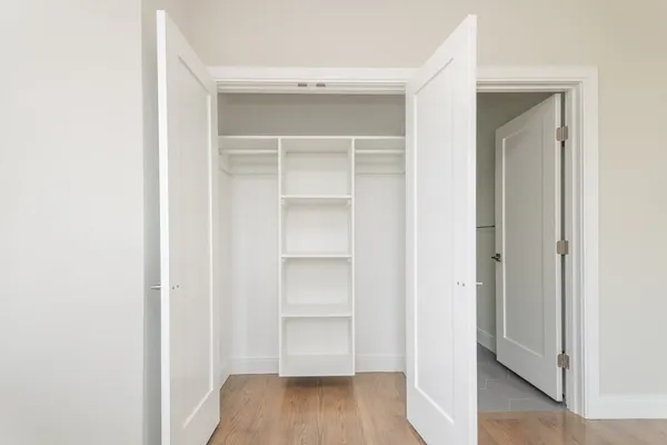 a view of walk in closet with wooden floor