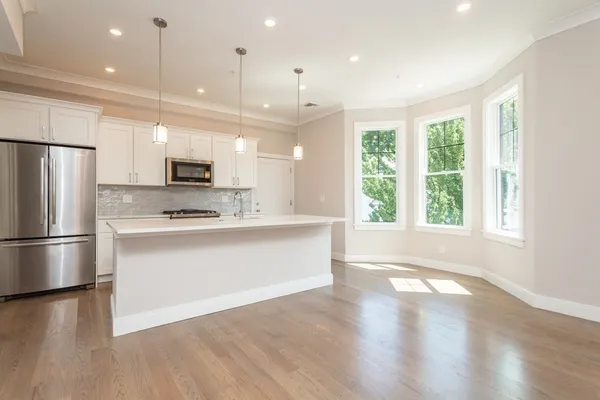 a large kitchen with a large window and stainless steel appliances