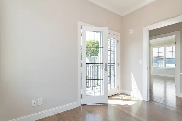 an empty room with wooden floor and windows