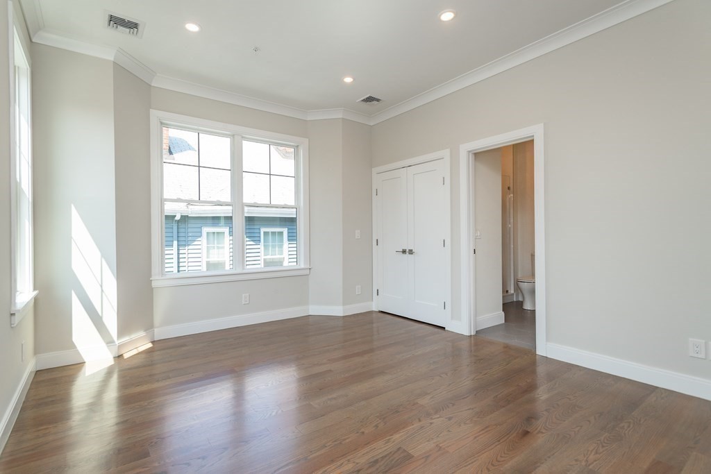 3247 Washington Street, Unit 3 Boston, MA 02130 - Photo 8 of 15 a view of an empty room with wooden floor and a window