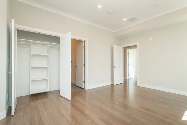 an empty room with wooden floor & closet and bathroom