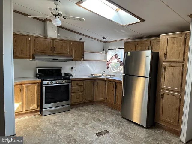 a kitchen with stainless steel appliances granite countertop a refrigerator stove and a sink