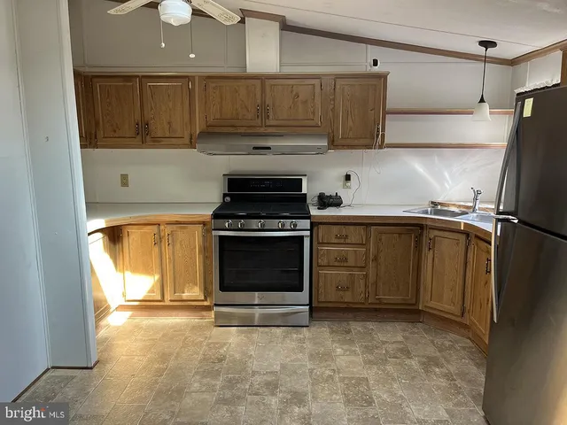 a kitchen with stainless steel appliances granite countertop a stove a sink and a refrigerator