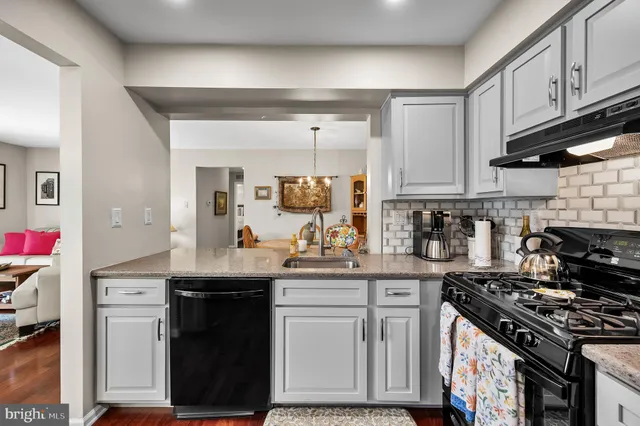 a kitchen with stainless steel appliances granite countertop a sink stove and cabinets