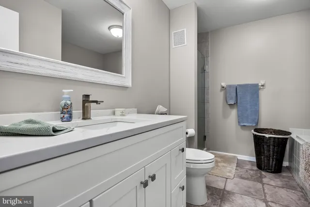 a bathroom with a granite countertop sink a toilet and a mirror