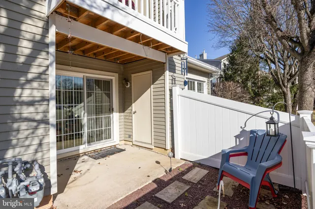 a view of a patio with a table and chairs and wooden fence