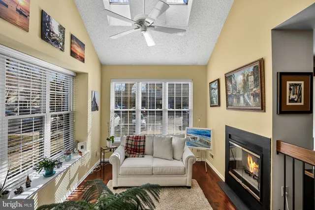 a living room with fireplace furniture and a large window