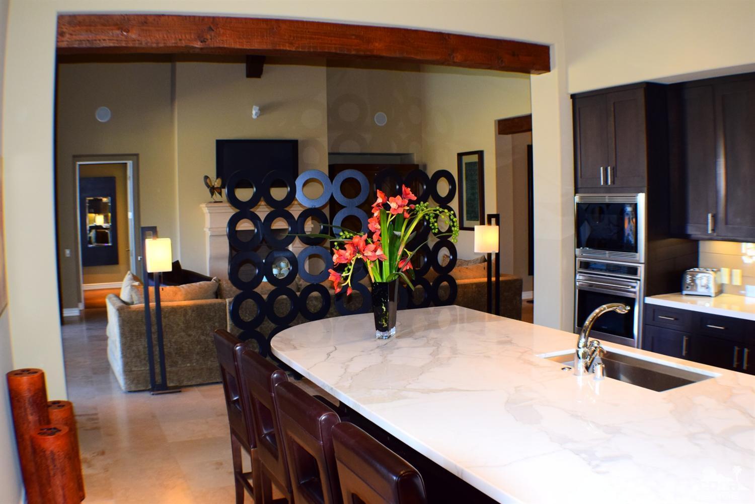 9 Santa Rosa Mountain Lane Rancho Mirage, CA 92270 - Photo 22 of 58 a kitchen with stainless steel appliances kitchen island granite countertop a refrigerator a stove and a sink with wooden floor