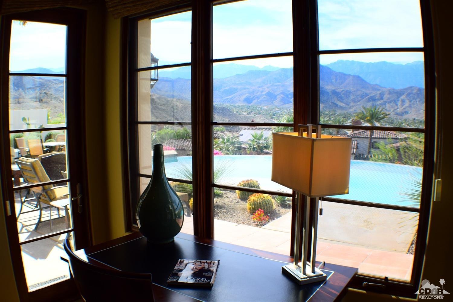 9 Santa Rosa Mountain Lane Rancho Mirage, CA 92270 - Photo 53 of 58 a living room with large windows and a table