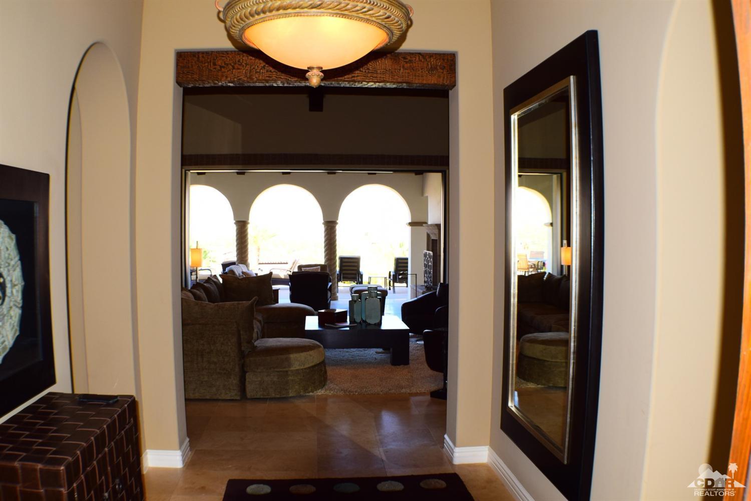9 Santa Rosa Mountain Lane Rancho Mirage, CA 92270 - Photo 10 of 58 a living room with a couch and a chandelier