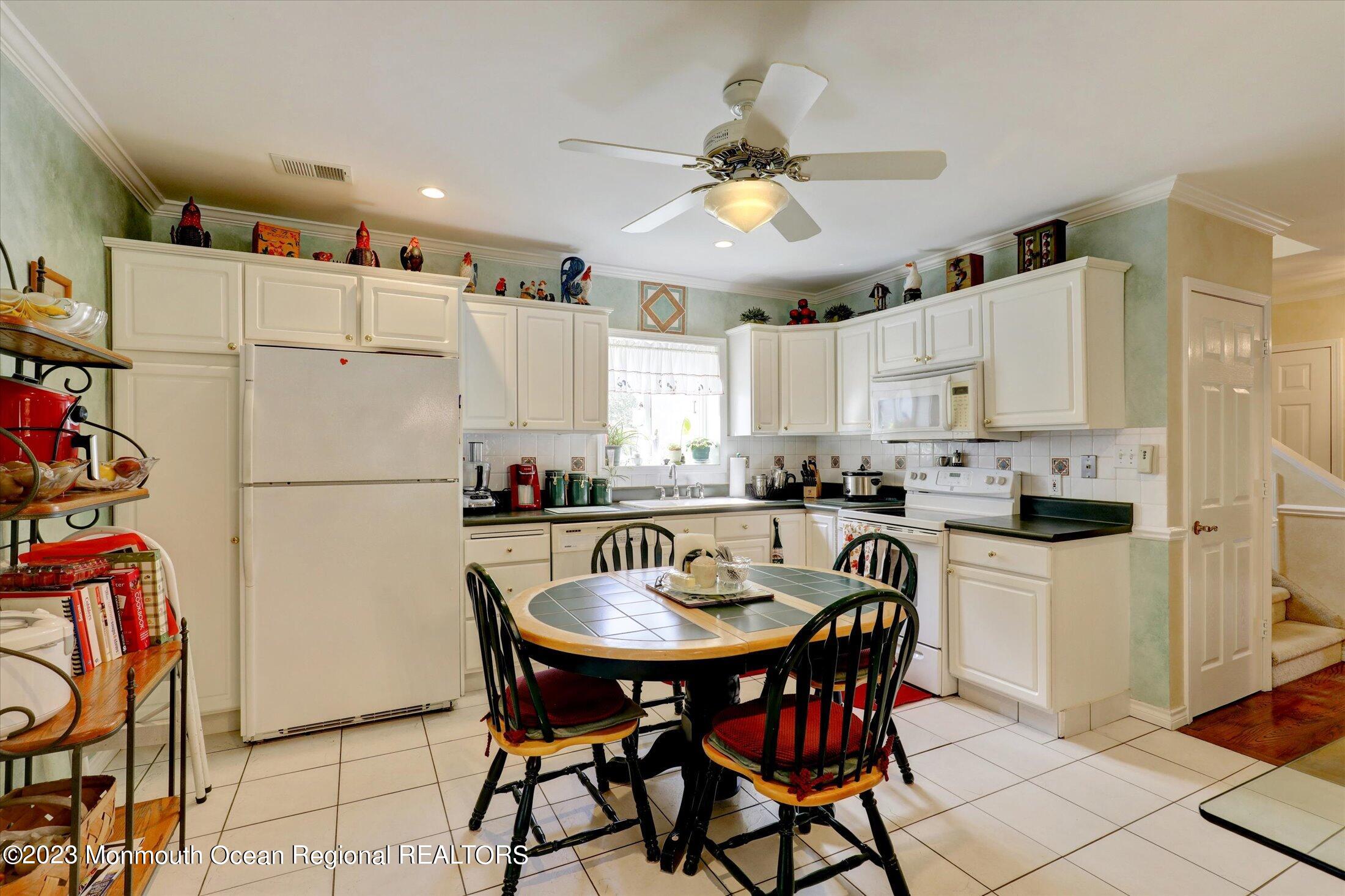 847 Waterworks Road Freehold, NJ 07728 - Photo 18 of 74 a kitchen with stainless steel appliances a refrigerator a stove a sink and white cabinets with wooden floor