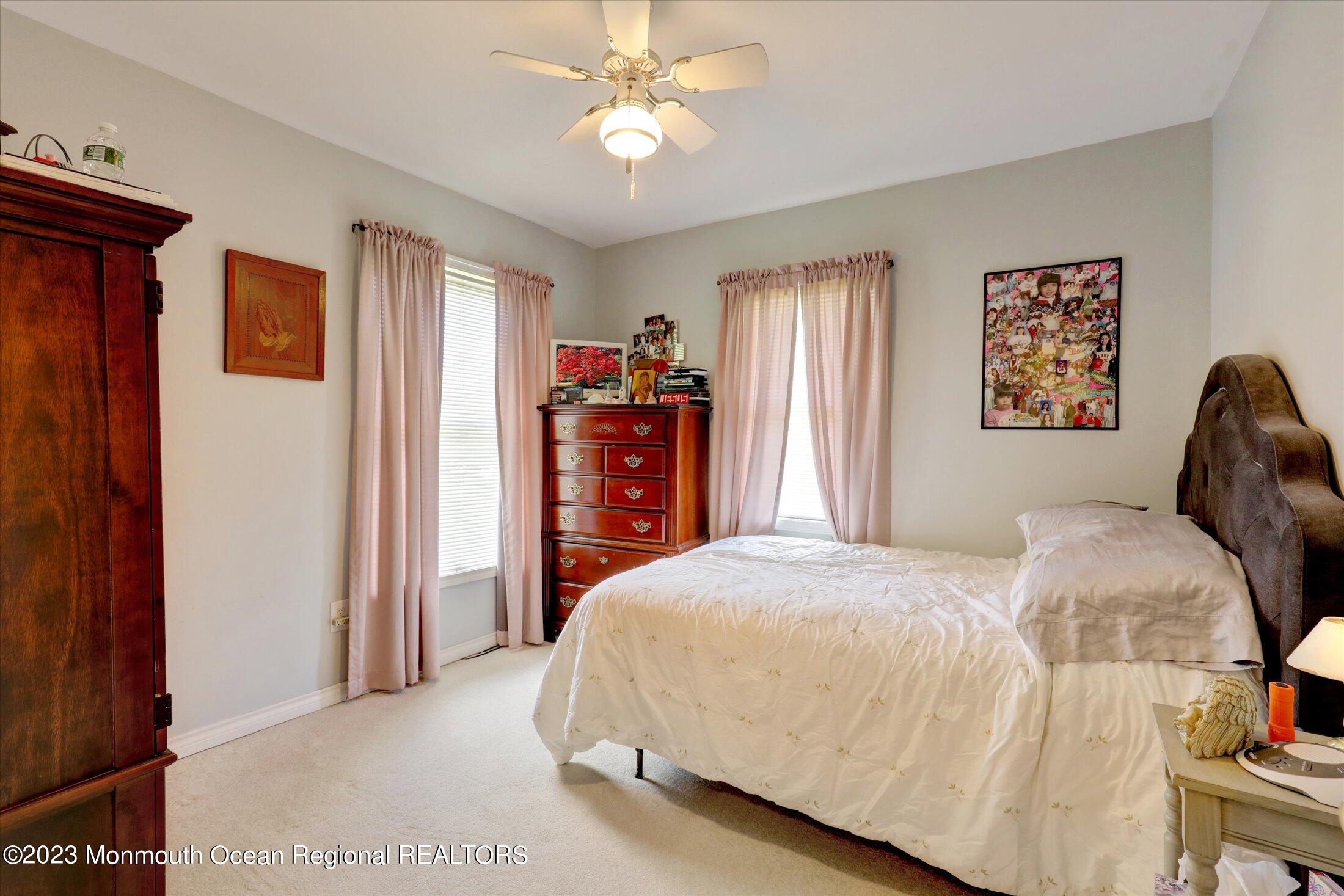 847 Waterworks Road Freehold, NJ 07728 - Photo 32 of 74 a bedroom with a bed and a chandelier