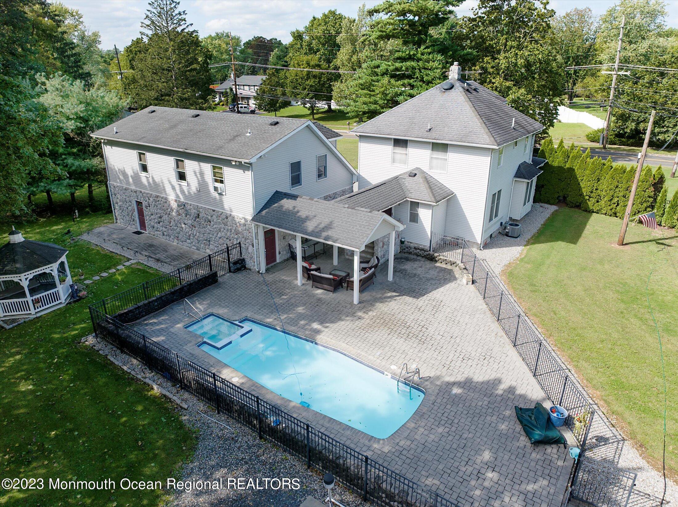 847 Waterworks Road Freehold, NJ 07728 - Photo 38 of 74 a aerial view of a house with table and chairs under an umbrella