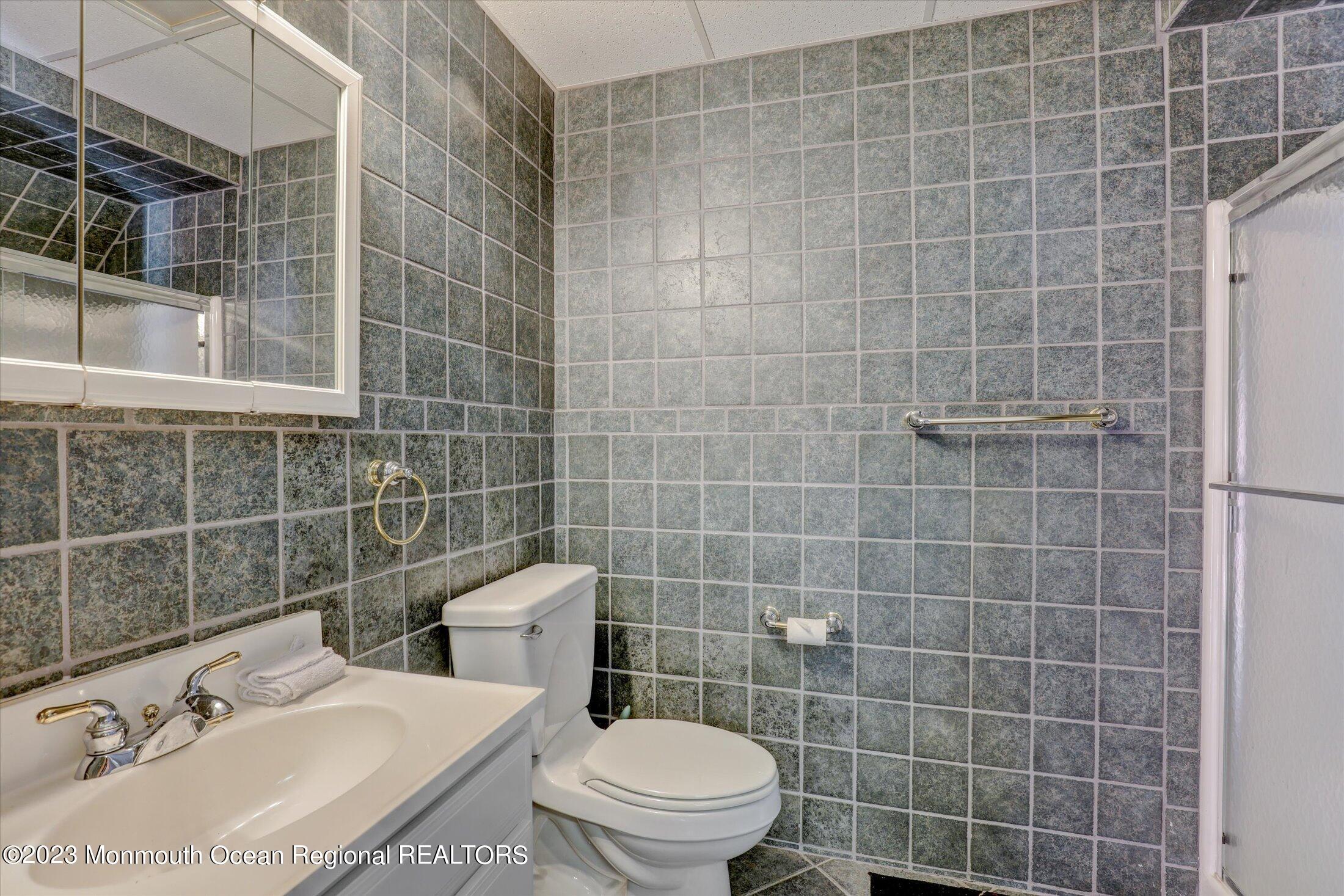 847 Waterworks Road Freehold, NJ 07728 - Photo 52 of 74 a bathroom with a sink a toilet and a mirror
