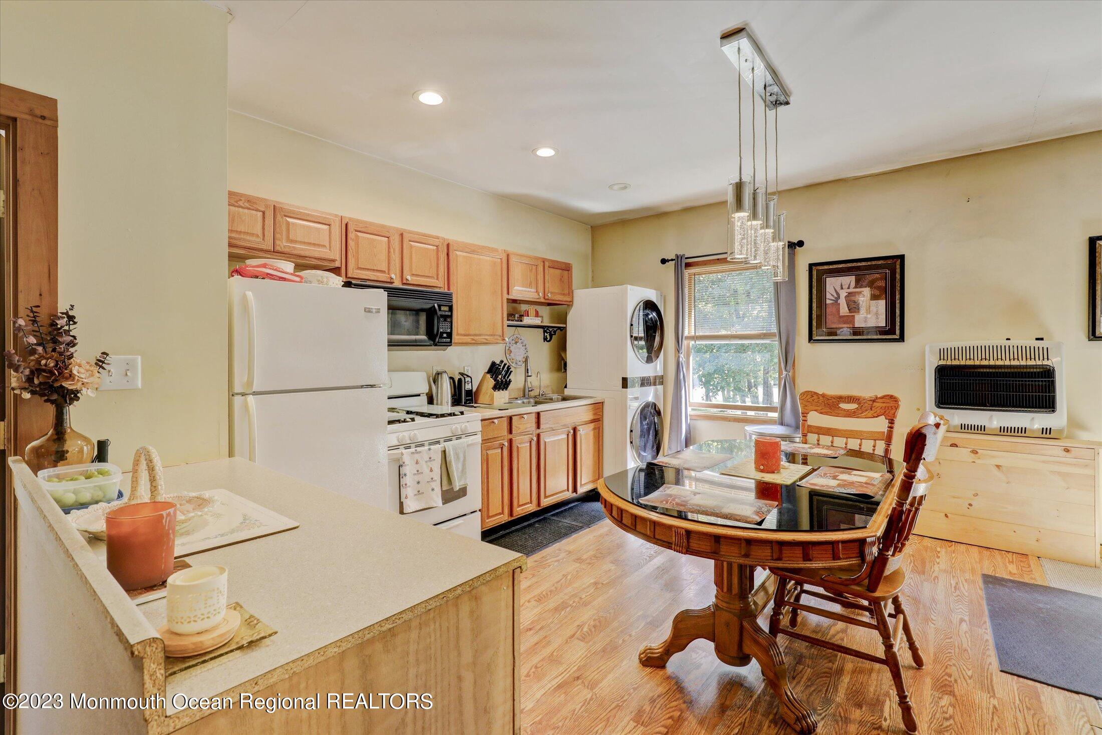 847 Waterworks Road Freehold, NJ 07728 - Photo 56 of 74 a kitchen with stainless steel appliances kitchen island granite countertop a refrigerator a stove a microwave oven with a dining table and chairs