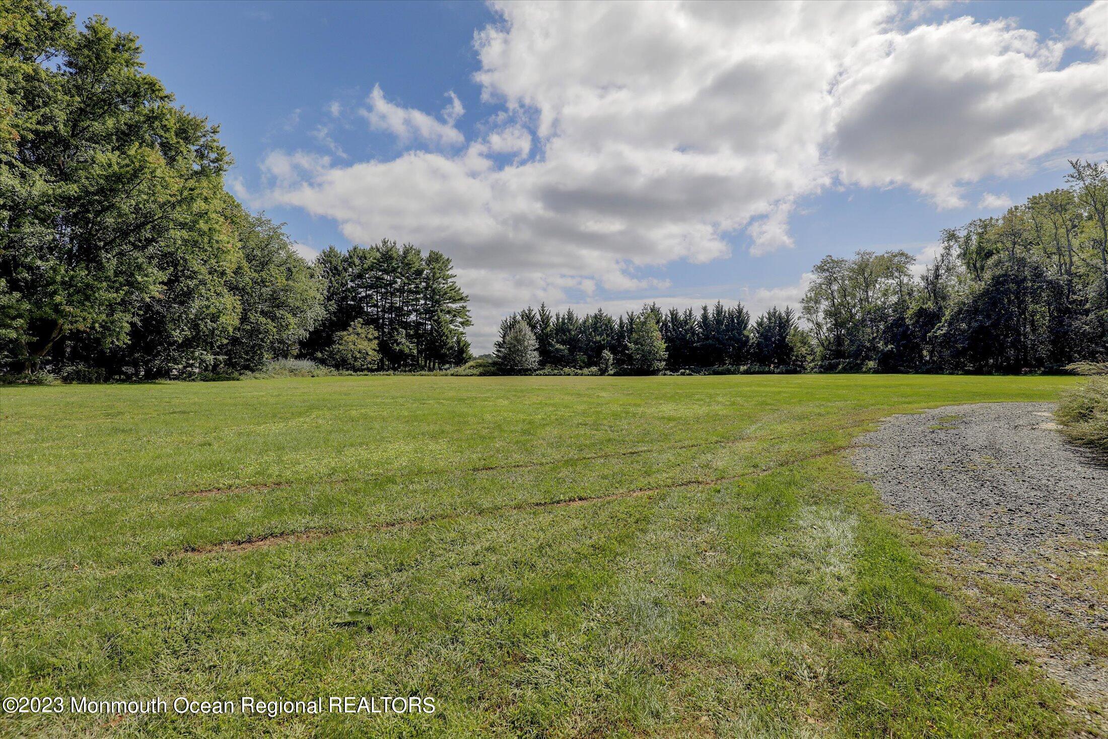 847 Waterworks Road Freehold, NJ 07728 - Photo 70 of 74 a view of a grassy field with trees in the background