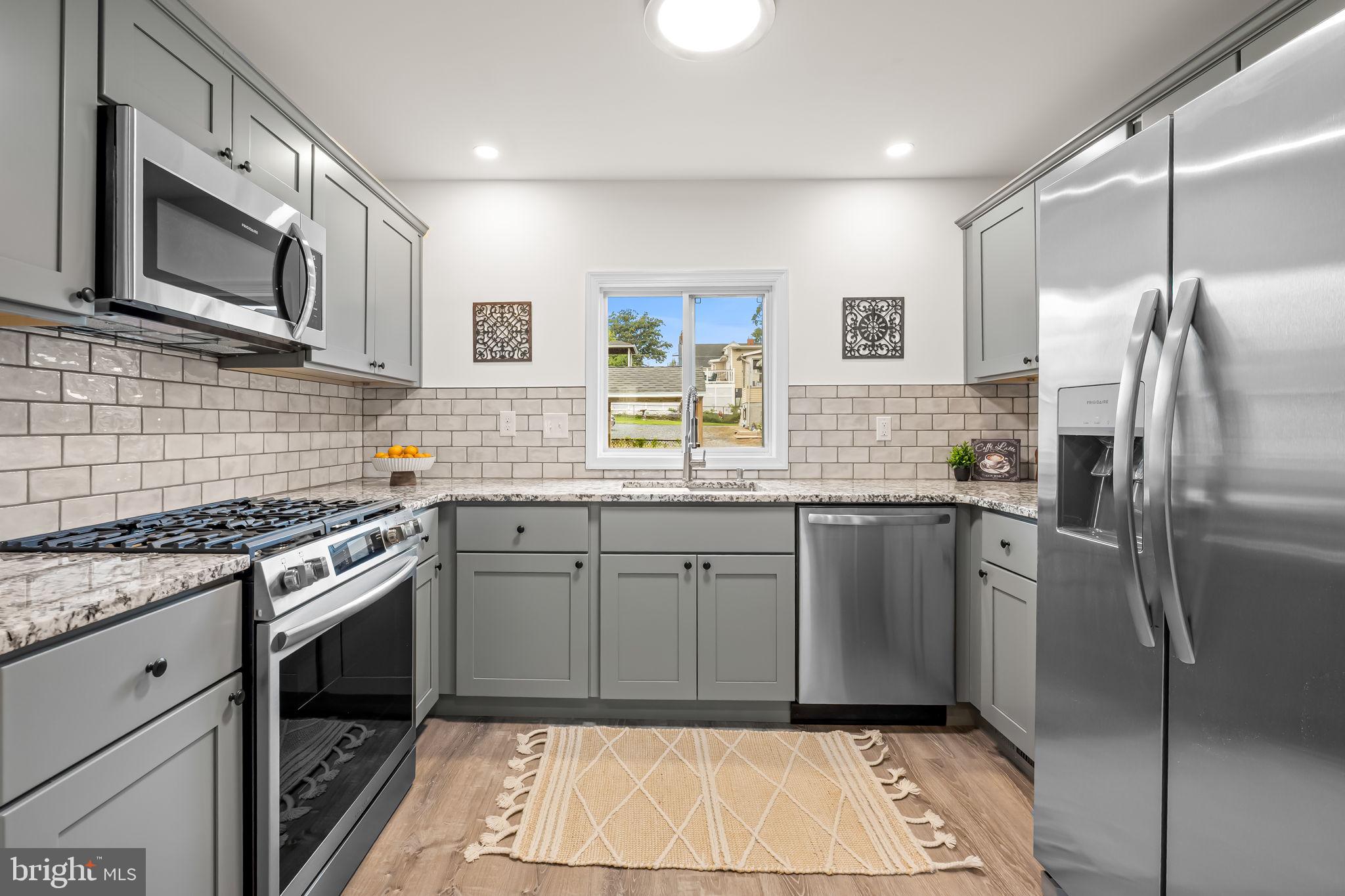 628 North Stuart Street Baltimore, MD 21221 - Photo 11 of 39 a kitchen with stainless steel appliances granite countertop a stove a sink and a refrigerator