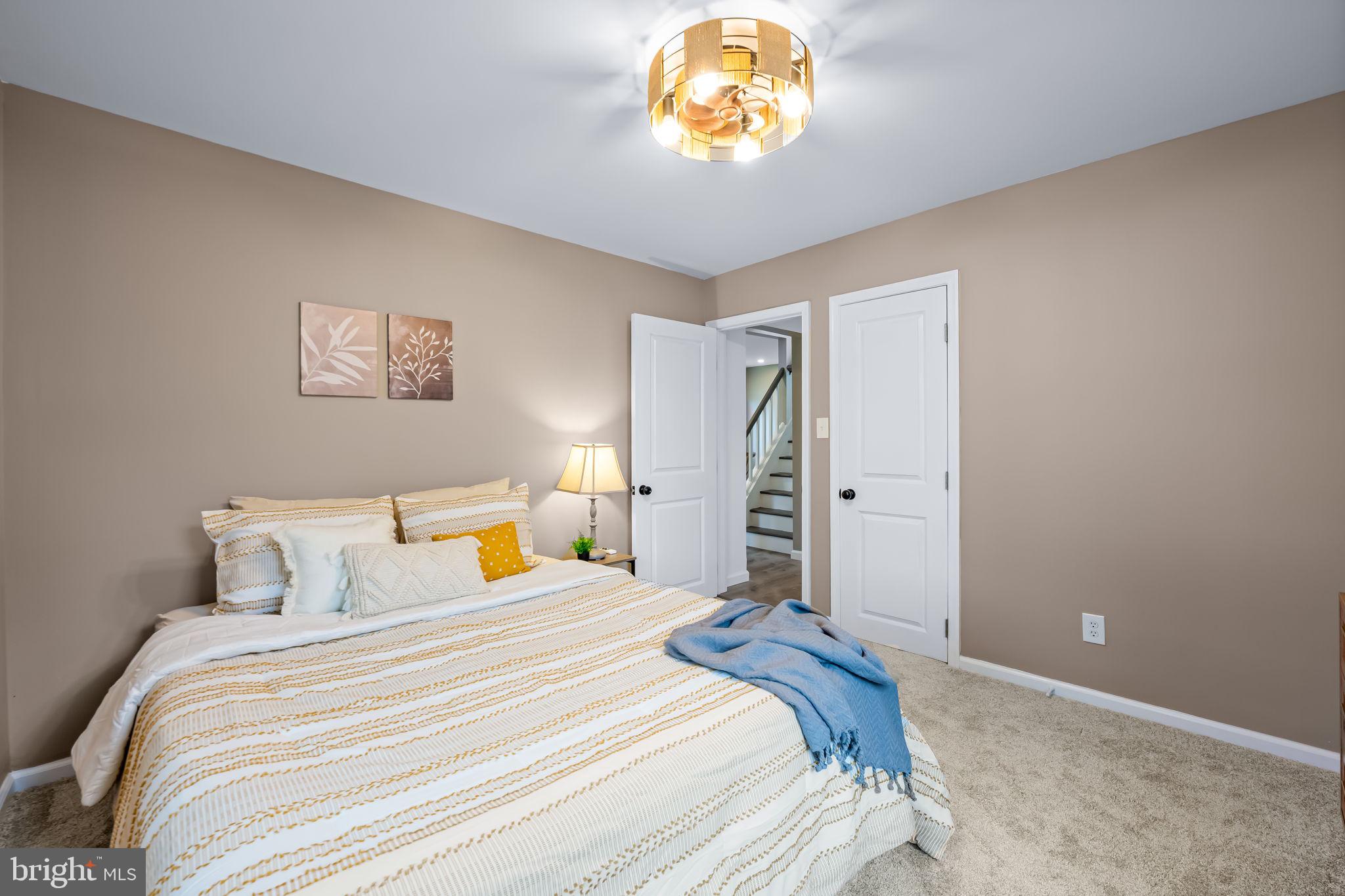 628 North Stuart Street Baltimore, MD 21221 - Photo 21 of 39 a bedroom with a bed and a chandelier