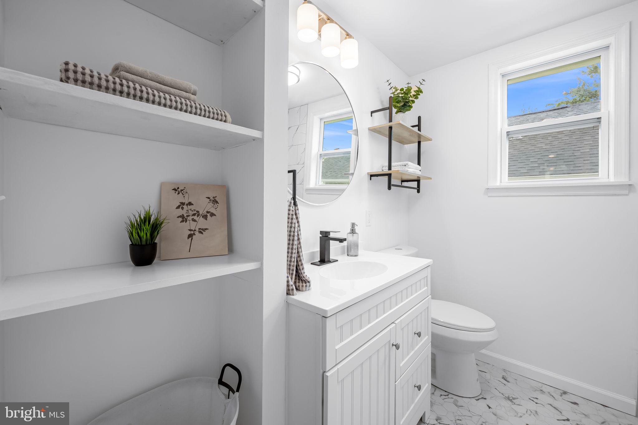 628 North Stuart Street Baltimore, MD 21221 - Photo 22 of 39 a bathroom with a sink a toilet and mirror