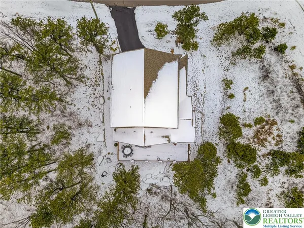 a living room with couches and kitchen view with wooden floor