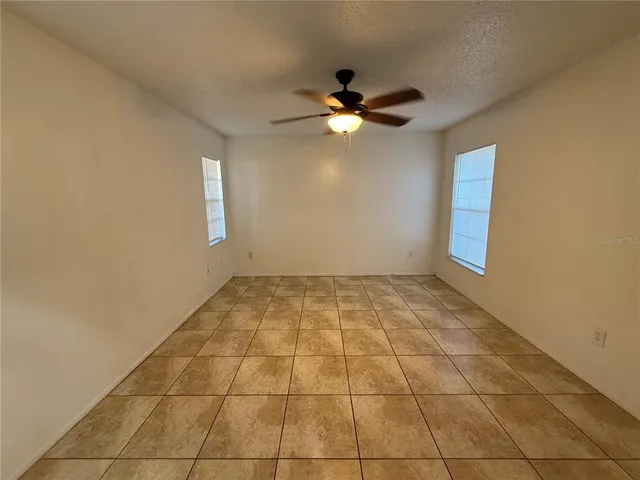 a view of an empty room with wooden floor and window