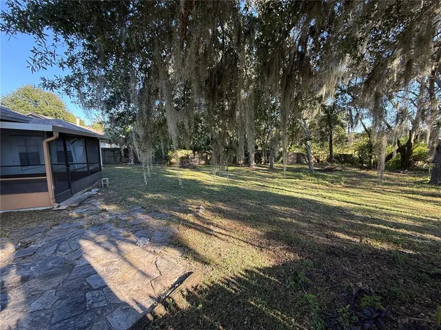 a backyard of a house with lots of plants and tree