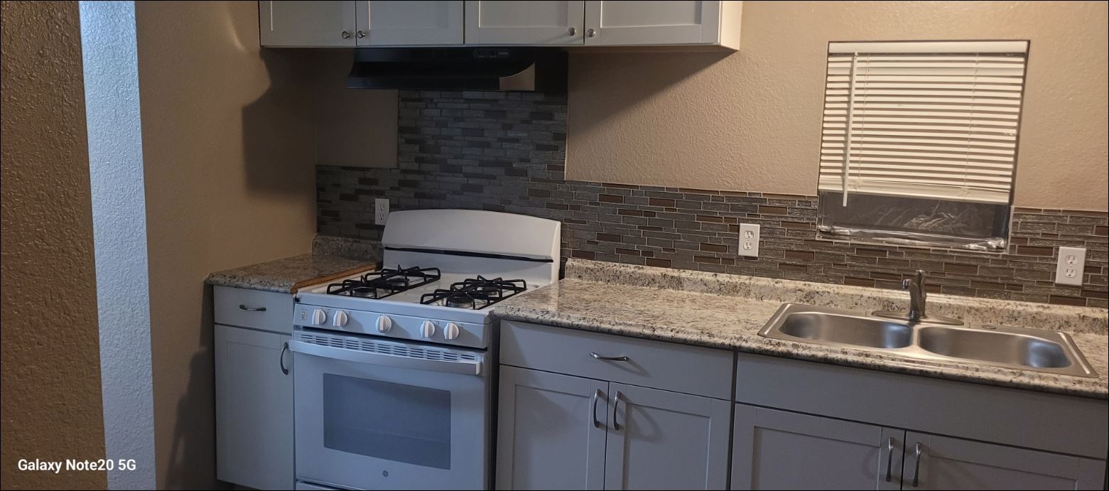 349 State Highway 95 Elgin, TX 78621 - Photo 4 of 16 Kitchen with a textured wall, gas range gas stove, backsplash, and white cabinets
