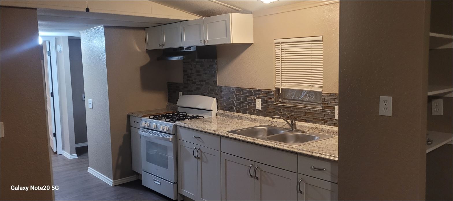 349 State Highway 95 Elgin, TX 78621 - Photo 5 of 16 Kitchen featuring white gas range oven, backsplash, white cabinets, and light countertops
