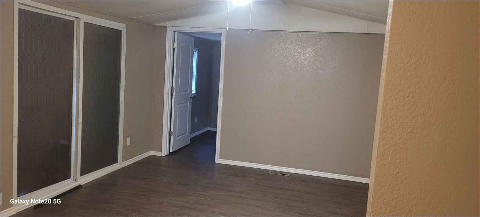 349 State Highway 95 Elgin, TX 78621 - Photo 7 of 16 Hallway featuring dark wood-type flooring, a textured wall, and lofted ceiling