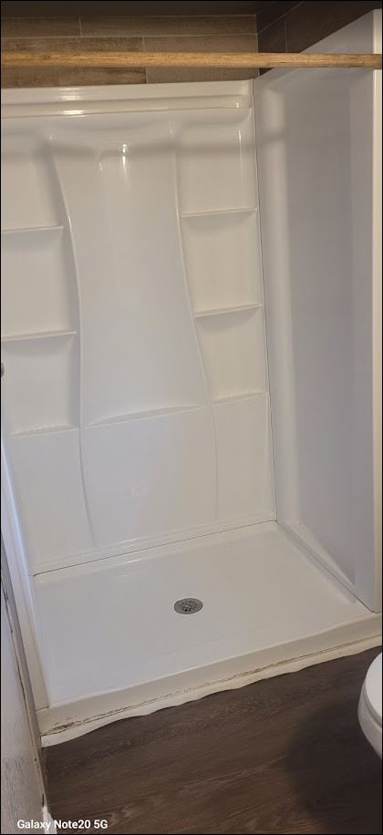 349 State Highway 95 Elgin, TX 78621 - Photo 8 of 16 Bathroom with a stall shower and dark wood-type flooring