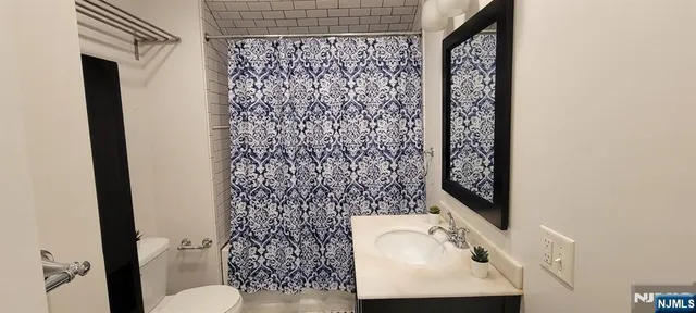 a bathroom with a toilet sink and shower curtain