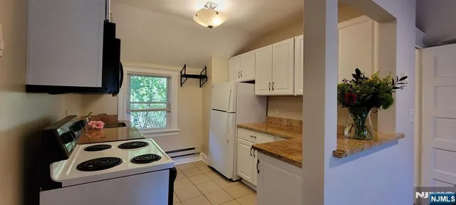 a kitchen with stainless steel appliances a sink a stove a refrigerator and cabinets
