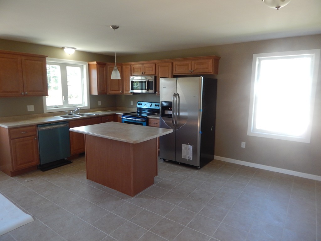 57 Frederick Street Fall River, MA 02721 - Photo 5 of 13 a kitchen with stainless steel appliances granite countertop a stove a sink a refrigerator and a microwave oven