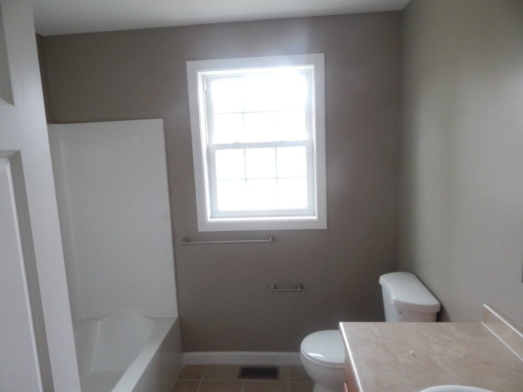 57 Frederick Street Fall River, MA 02721 - Photo 8 of 13 a white toilet sitting next to a bathroom sink