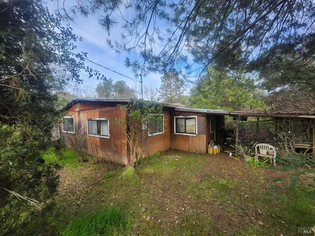 a view of a chair and table in backyard of the house