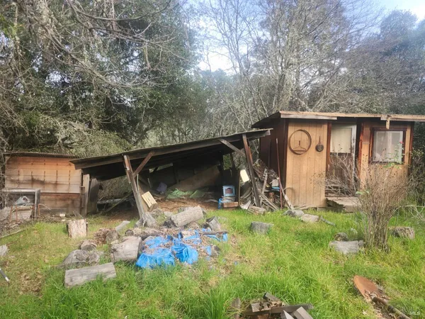 a view of backyard with wooden fence and a porch