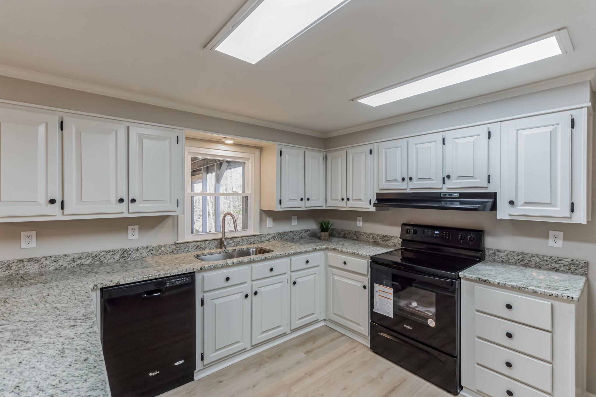 444 Culler Road Pinnacle, NC 27043 - Photo 5 of 34 a kitchen with granite countertop white cabinets and black appliances