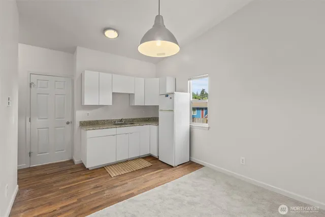 a room with kitchen island white cabinets and window