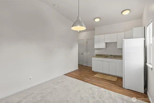 a kitchen with a refrigerator and white cabinets