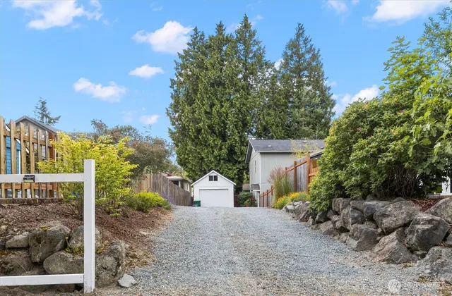 a large kitchen with stainless steel appliances granite countertop a stove top oven a sink dishwasher a refrigerator and white cabinets with wooden floor