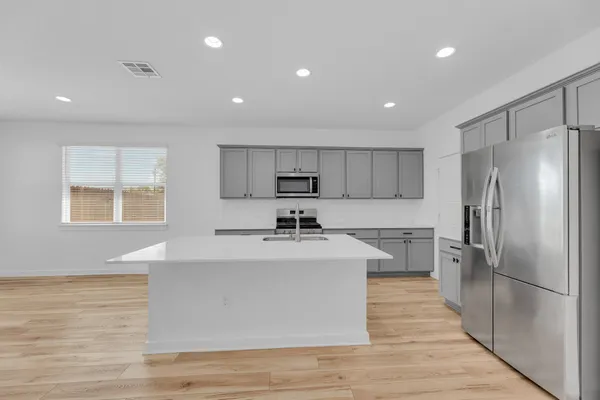a kitchen with a refrigerator sink and cabinets