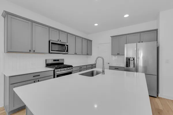 a kitchen with stainless steel appliances granite countertop a refrigerator sink and wooden cabinets