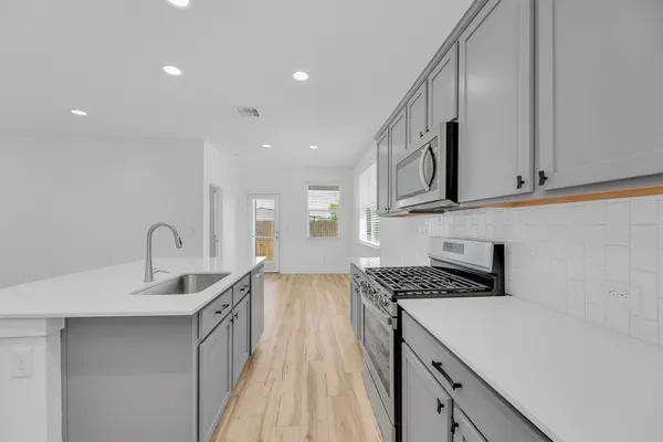 a kitchen with stainless steel appliances a refrigerator stove microwave and sink