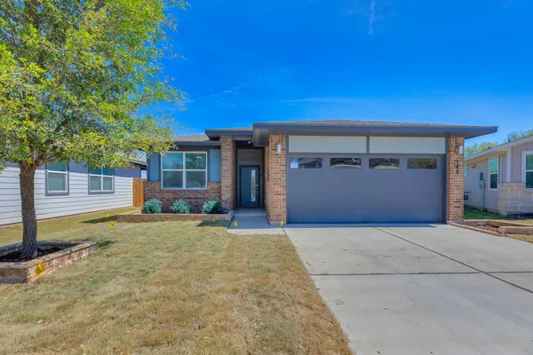 a view of a house with a yard and garage