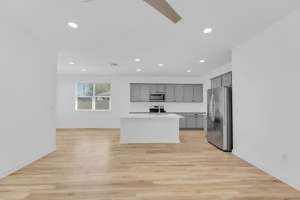 a kitchen with a refrigerator and white cabinets