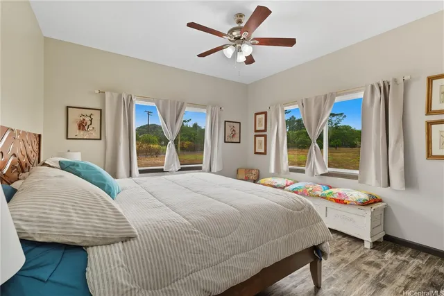 a bedroom with a bed large window with chair and table