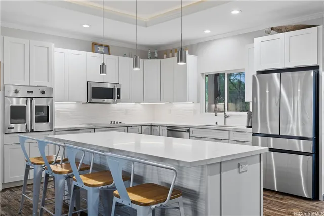 a kitchen with stainless steel appliances a stove a sink a microwave a refrigerator and cabinets