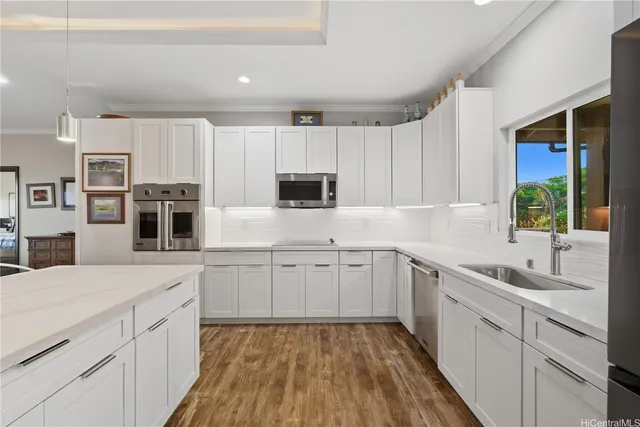 a kitchen with kitchen island white cabinets appliances and a window