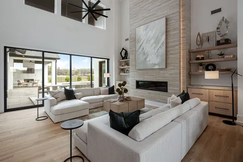 a living room with fireplace furniture and a large window