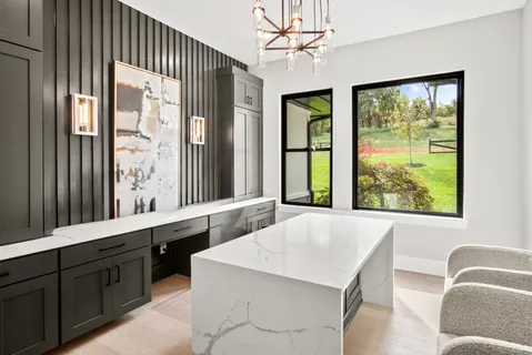 a living room with stainless steel appliances granite countertop furniture and a large window